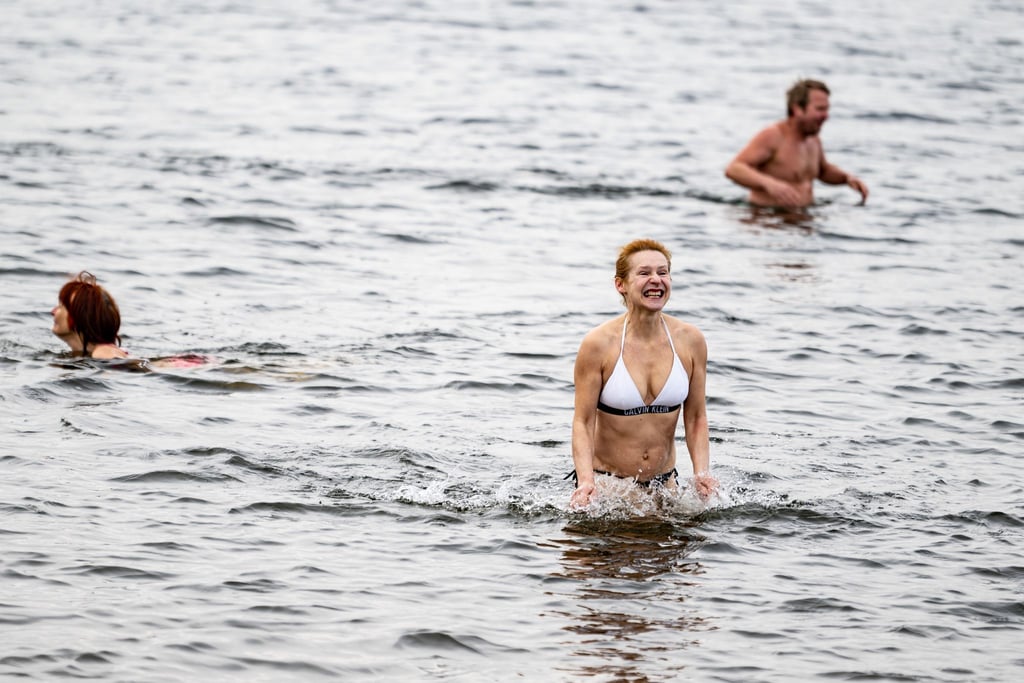 Gabriela (M) testet beim traditionellen Anbaden im Strandbad Wannsee am Karfreitag das Wasser.