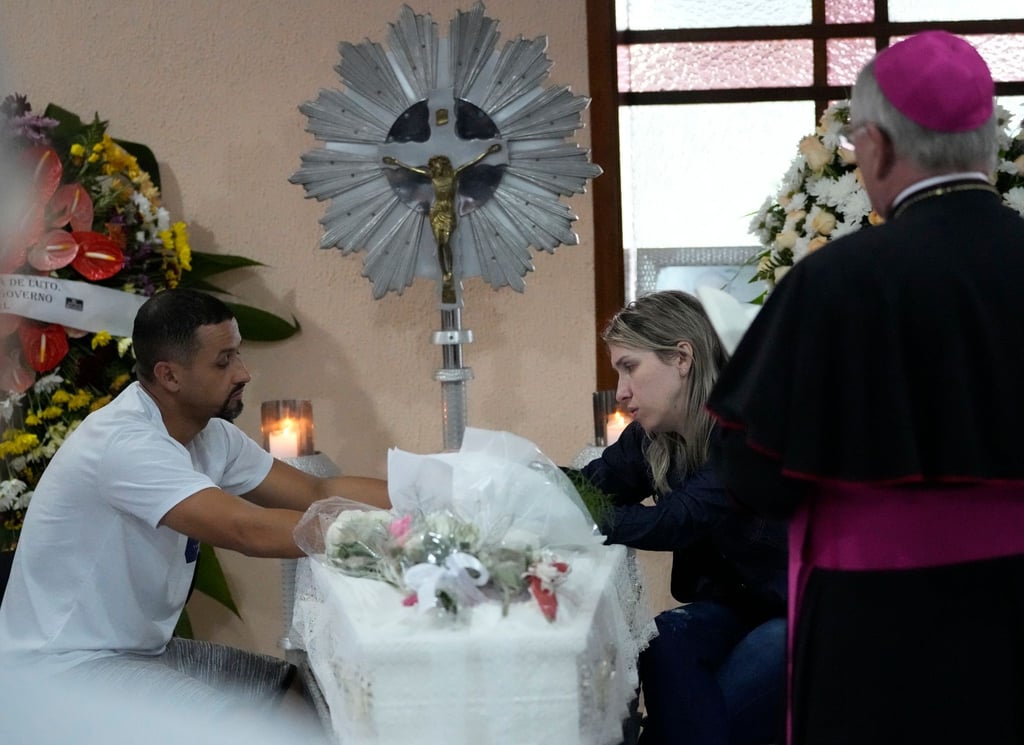 Eltern sitzen während einer Totenwache in Blumenau neben dem Sarg mit den sterblichen Überresten ihrer siebenjährigen Tochter, die in der Kinderkrippe getötet wurde.