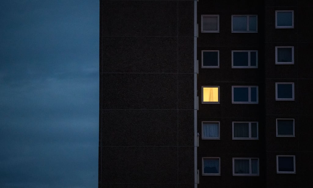 Licht brennt nur in einer Wohnung eines Mehrfamilienhauses.