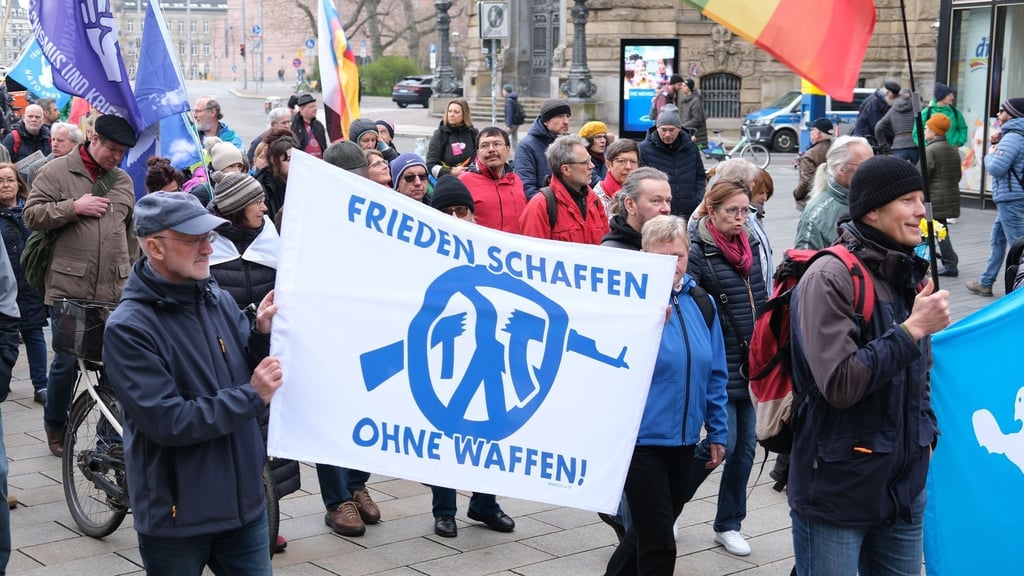 Demonstrierende gehen mit Fahnen und Transparenten auch durch das Stadtzentrum in leipzig. Foto: Sebastian Willnow/dpa