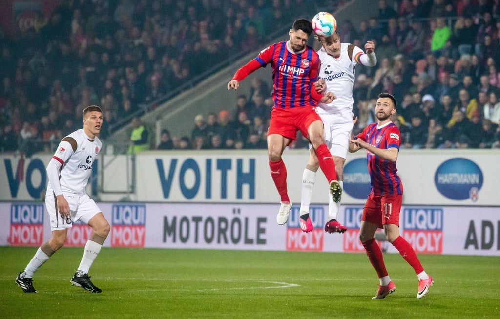 Heidenheims Tim Kleindienst (3.v.r) steigt gegen St. Paulis Jackson Irvine (2.v.r) zum Kopfball hoch.
