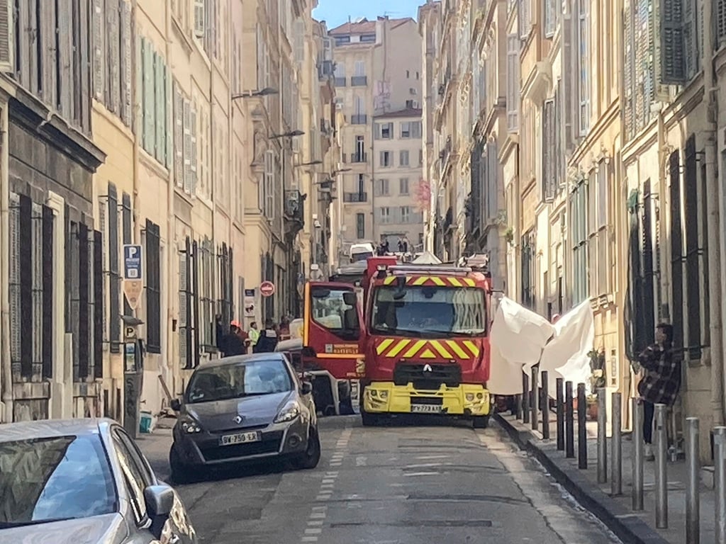 Ein Feuerwehrauto steht in einer Straße in der Nähe der Stelle, an der das Gebäude eingestürzt ist.