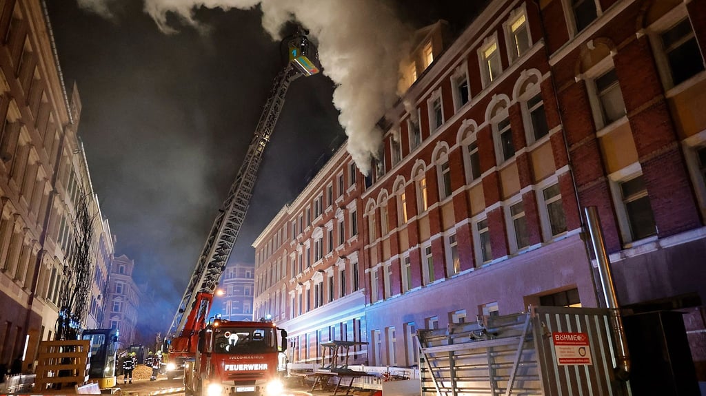 Feuerwehrleute löschen einen Wohnungsbrand.