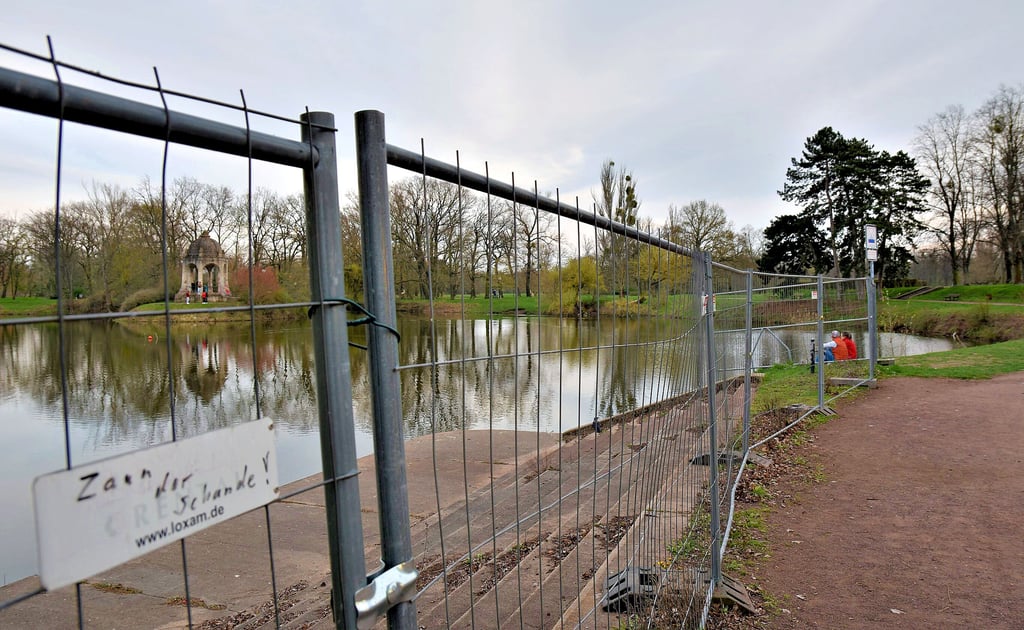 Der Adolf-Mittag-See ist ein beliebter Treffpunkt im Magdeburger Stadtpark. Durch den Metallzaun ist der Tempel auf der Marieninsel zu erkennen.