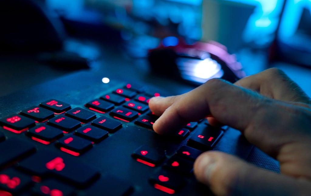 Ein Mann sitzt am Rechner und tippt auf einer Tastatur.
