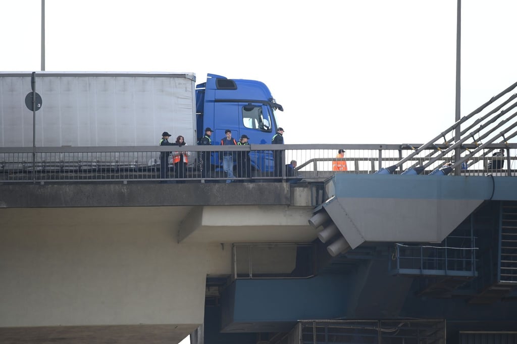 Aktivisten der Gruppe Letzte Generation und Polizisten stehen auf der Köhlbrandbrücke.