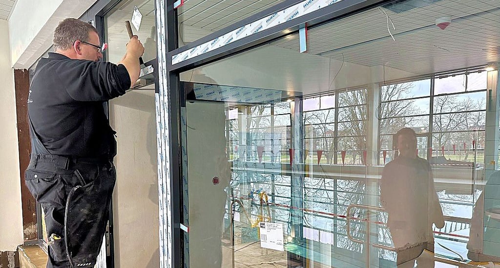 Letzte Arbeiten vor der Eröffnung der Burger Schwimmhalle an der Glas-Abtrennung zum Schwimmmeister-Raum.