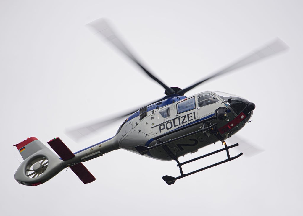 Ein Polizeihubschrauber fliegt bei einem Sucheinsatz über eine Stadt.