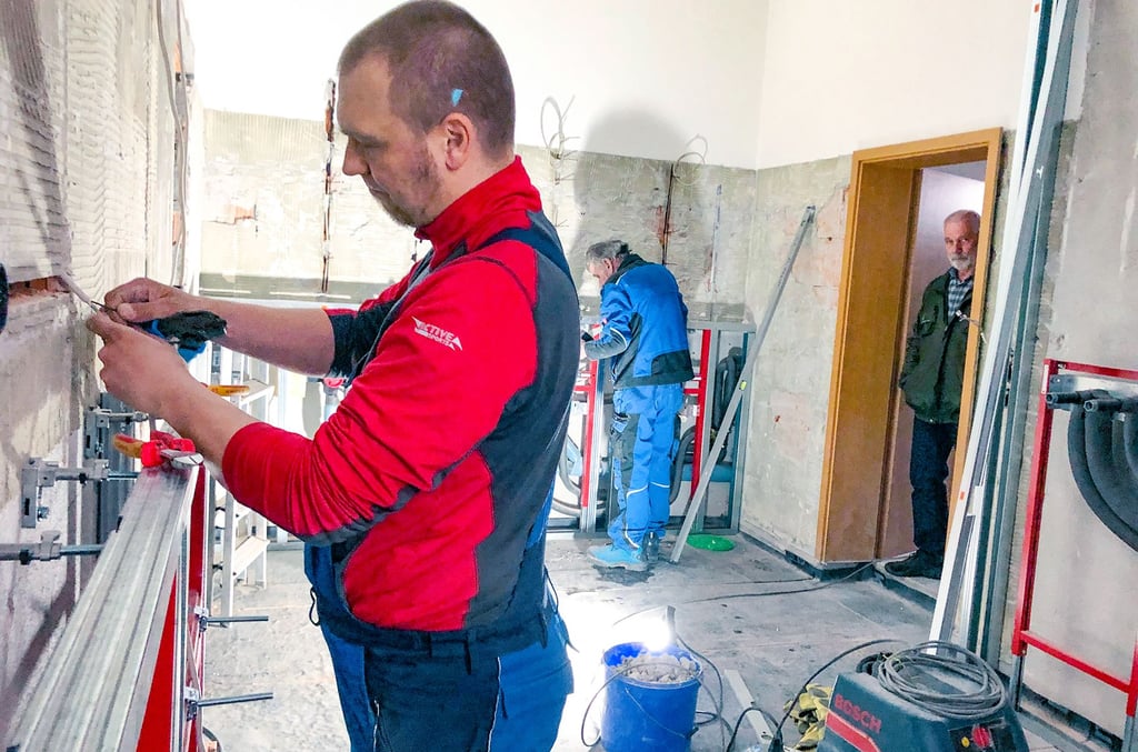 Ronny Wagner (vorn) und Klaus-Dieter Fischbach, Mitarbeiter der Firma Elektro-Wagner Bad Suderode, bei Elektroarbeiten im Duschraum des Feuerwehrgerätehauses Gernrode.