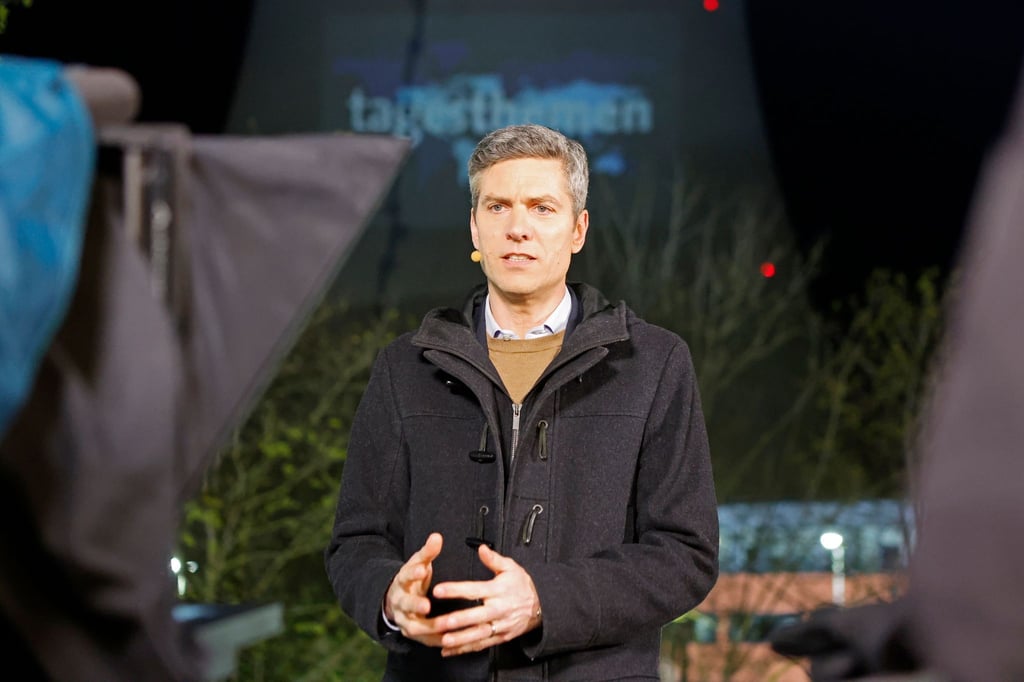Ingo Zamperoni moderiert die ARD-Tagesthemen von einem Balkon vor dem Kühlturm des AKW Isar 2.