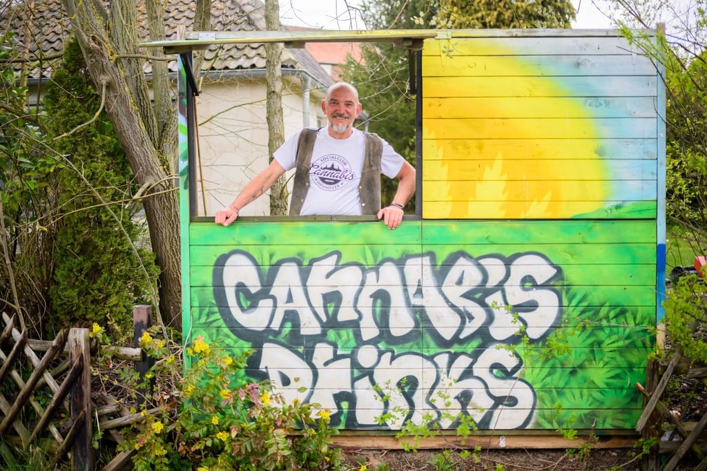 Heinrich Wieker vom Cannabis Socialclub Hannover e.V. an seinem Gartenzaun an einer Bretterbude.