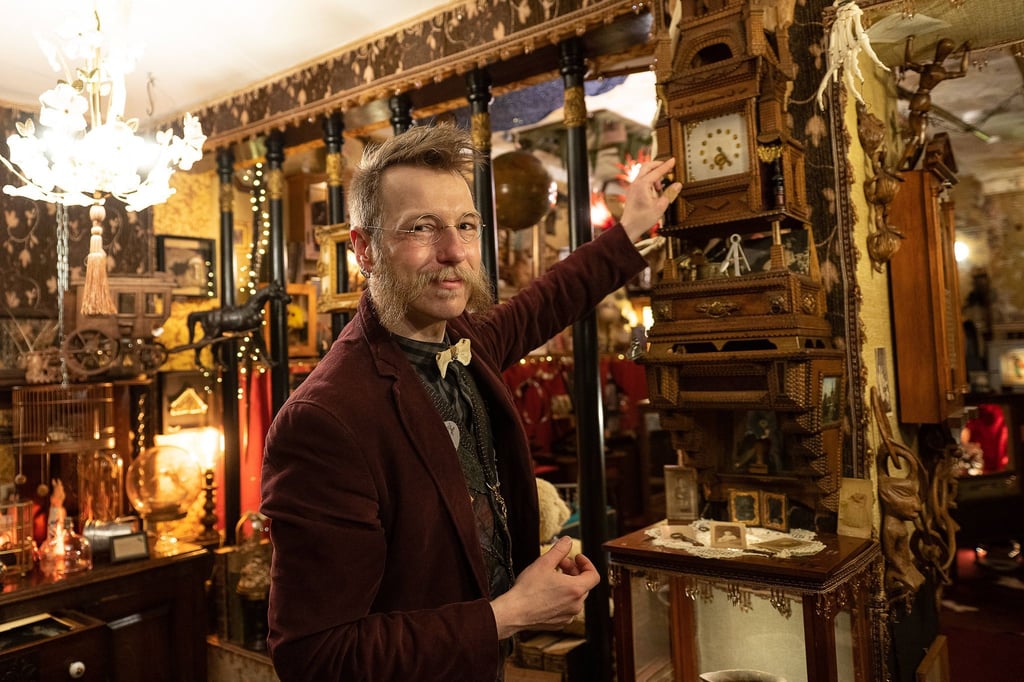 Daniel Rudolph Wolf Graf von Ladonien, Leiter des Vereins Denkräume für Kulturgeschichte, steht neben einer Uhr aus Zigarrenkisten im Kuriositäten-Museum „Dr. Wolfs Wunderkammer“.