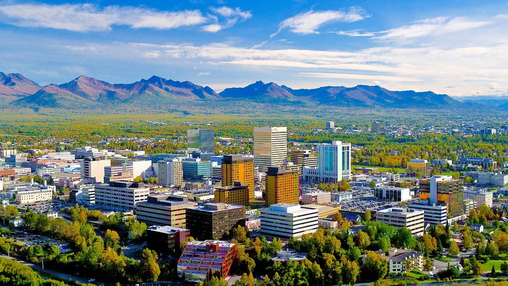 Skyline in grüner Weite mit Bergen am Horizont: Anchorage ist die größte Stadt in Alaska.