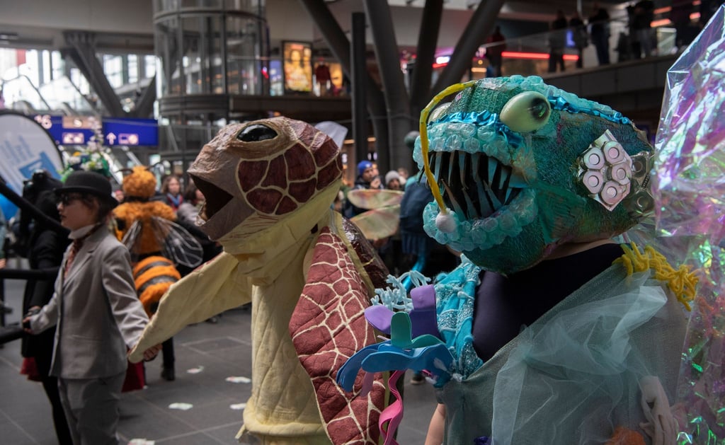 Klima-Aktivisten der Gruppe Extinction Rebellion tragen bei einem Tanz-Flashmob im Berliner Hauptbahnhof fantasievolle Tierkostüme.