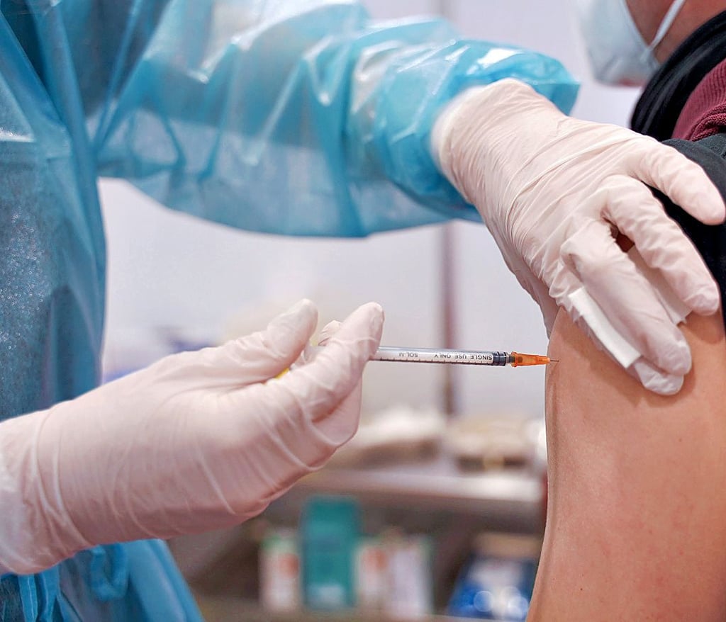 Ein junger Mann wird mit einer Booster-Dosis im Impfzentrum in der Potsdamer Schinkelhalle gegen Coronavirus geimpft.
