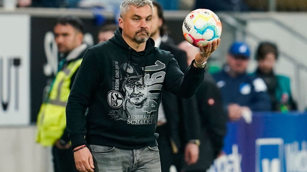 Schalkes Trainer Thomas Reis hält den Spielball in den Händen.