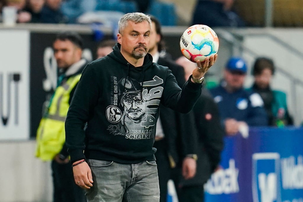 Schalkes Trainer Thomas Reis hält den Spielball in den Händen.