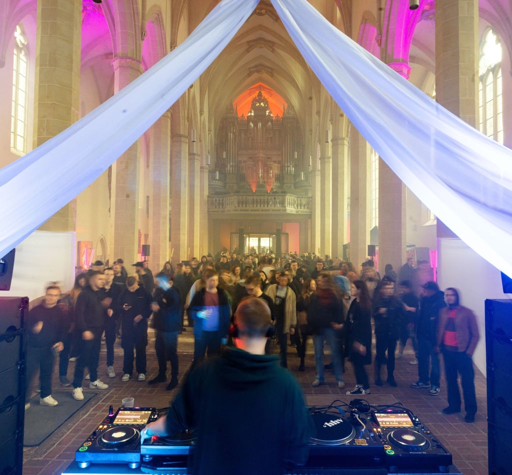 Menschen tanzen in der Predigerkirche beim Techno-Rave "Rave like God".