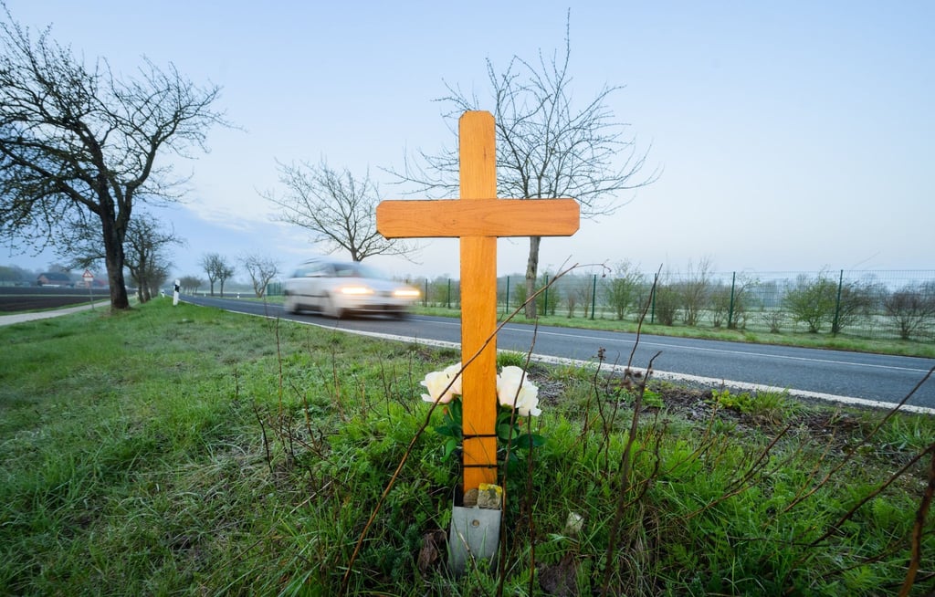 Ein Kreuz zum Gedenken an ein 21-jähriges Opfer eines Verkehrsunfalls steht an einer Landstraße.