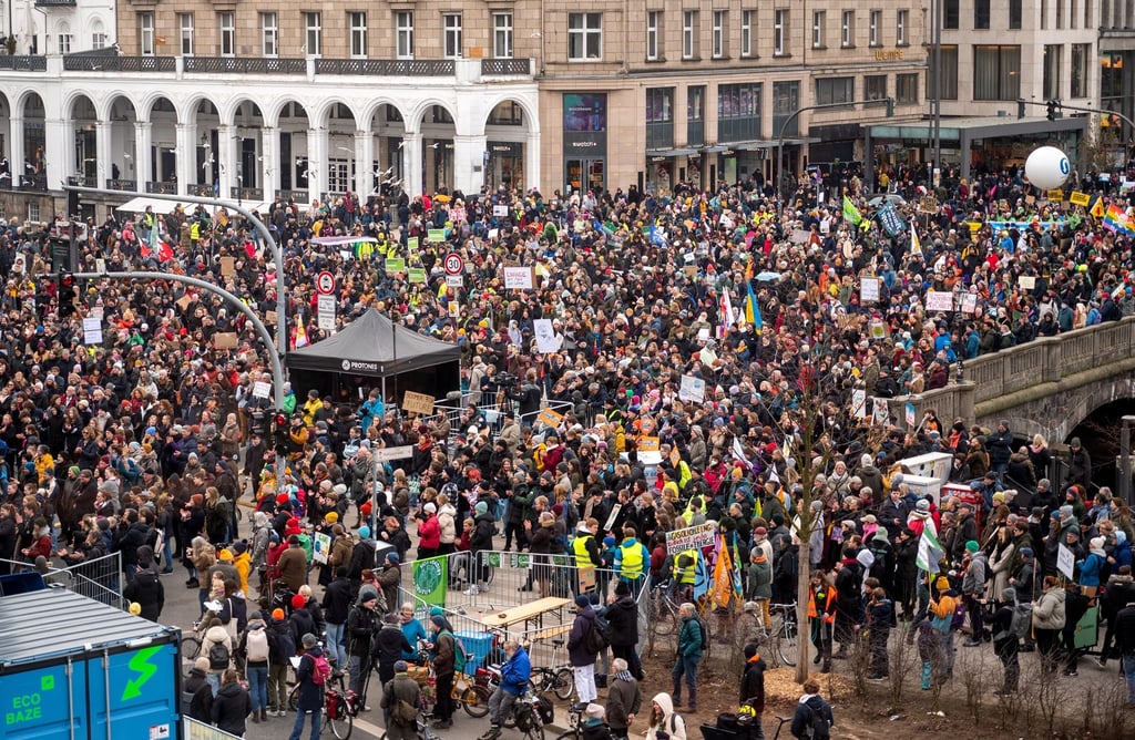 Teilnehmer der Fridays for Future - Demonstration stehen in der Innenstadt und halten Plakate und Transparente.
