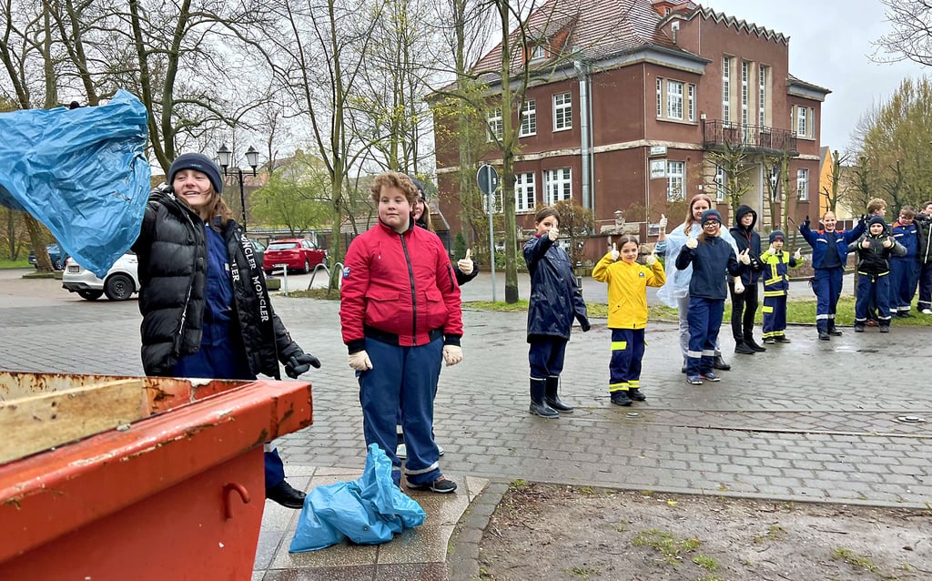 Hand in Hand gegen den Müll: Mitglieder der Holzweißiger Jugendfeuerwehr beluden bereitstehende Container mit Säcken voller Unrat.