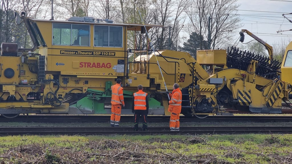 Bahn-Mitarbeiter untersuchen nach dem Unfall die Leitung in Langenhagen.