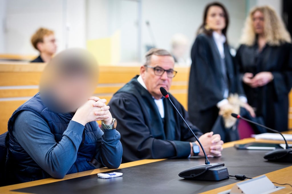 Die beiden Angeklagten (vorne l und oben M) sitzen im Gerichtssaal im Landgericht.