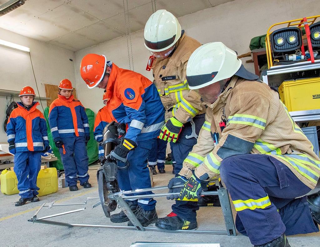 2. Ausbildungstag der Jugendfeuerwehren der Stadt Naumbrg und ihrer Ortsteile am Depot der FFW Bad Kösen Übung mit der Rettungsschere, die über Akku läuft. Oskar Hansch von der Feuerwehr Bad Kösen kann probieren, welche Kraft diese Schere hat. Damit nichts passiert passen Danny Fischer und Thomas Wagenhaus (v.l.) von der FF Naumburg auf.