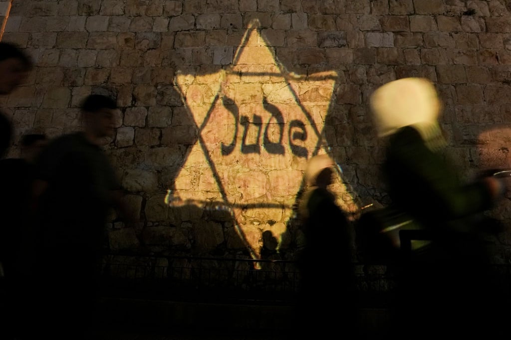 Ein gelber Davidstern mit der Aufschrift „Jude“, ähnlich dem, den Juden in Nazi-Deutschland tragen mussten, wird am Abend des jährlichen Holocaust-Gedenktages Yom HaShoah auf die Mauern der Jerusalemer Altstadt projiziert.