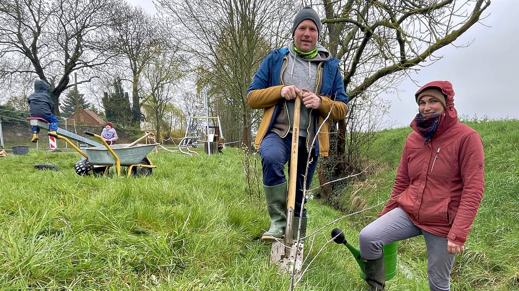 Lisa Werblow und Stephan Grützmann neben den ersten gepflanzten Büschen für die Wildhecke am Spielplatz.