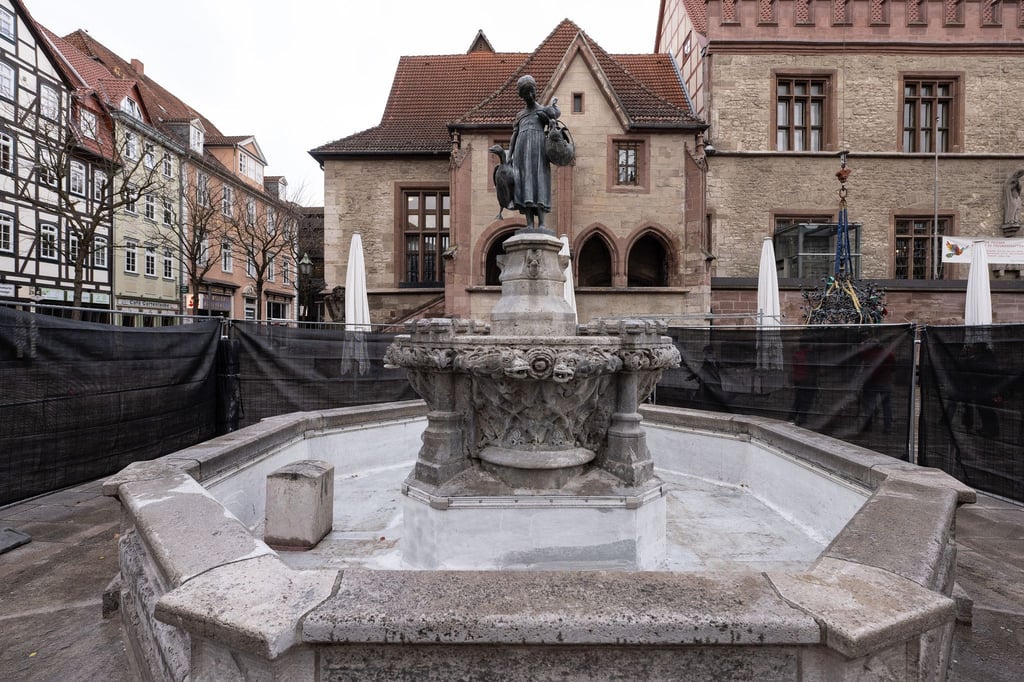 Blick auf den eingezäunten Gänselieselbrunnen auf dem Markt vor dem Alten Rathaus.