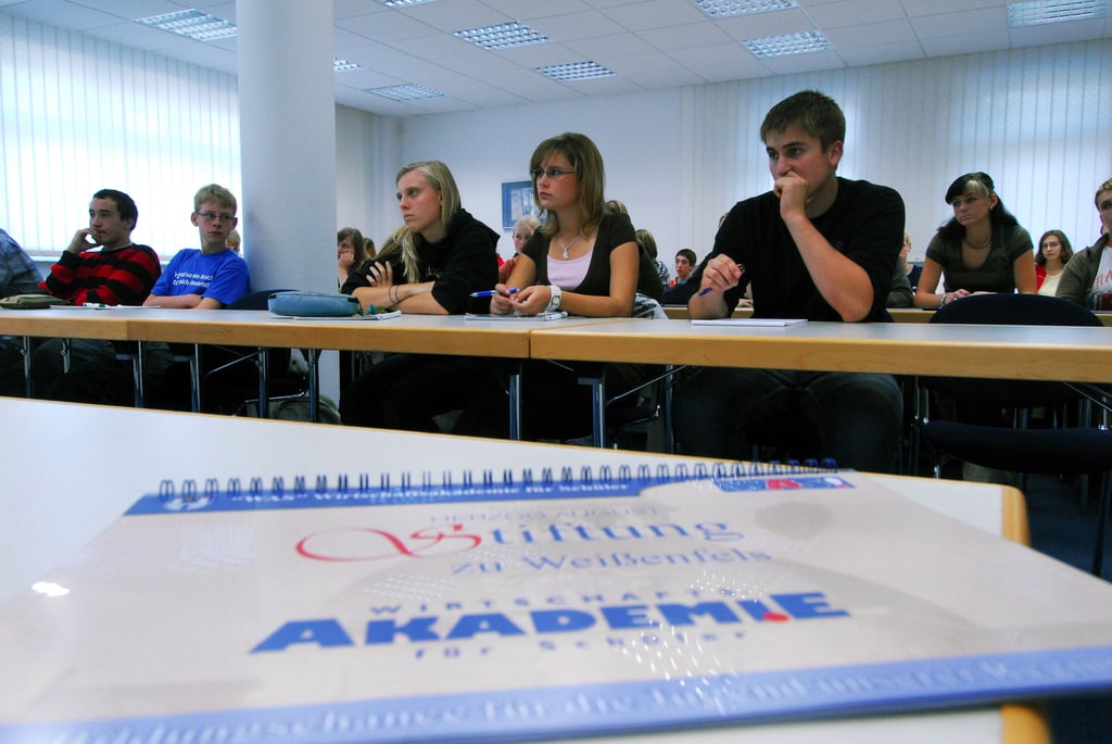 Junge Leute sitzen in der Wirtschaftsakademie für Schüler.