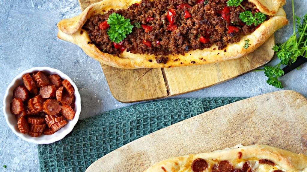 Die Fladenbrot-Schiffchen werden mit Käse und Kabanossiwurst oder Paprika-Hackfleisch-Mischung gefüllt.