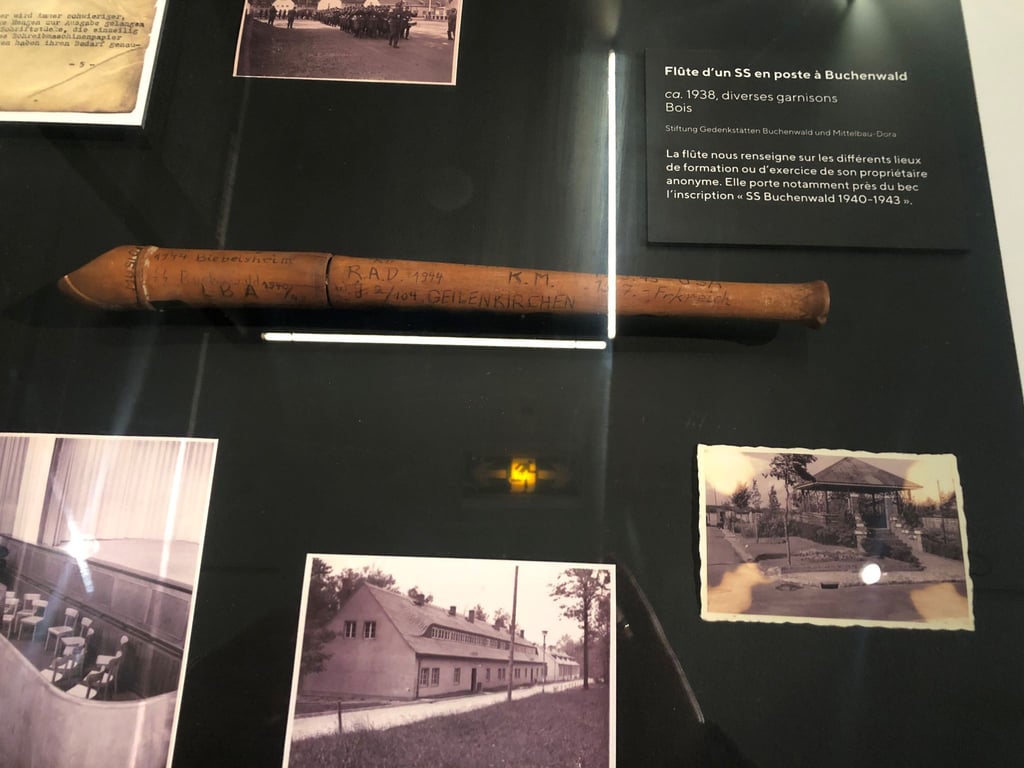 Eine Flöte eines SS-Manns im Konzentrationslager Buchenwald und Fotos in einer Vitrine.