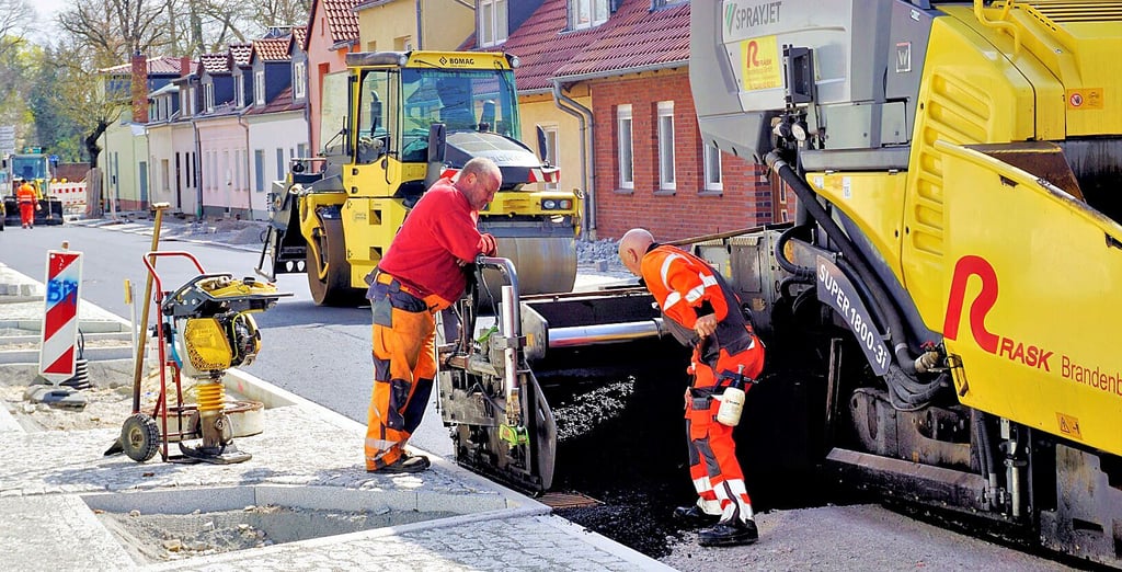 Bei Sonnenscheinwetter kommen die Straßenbauer mit der Asphaltierung zügig voran. 