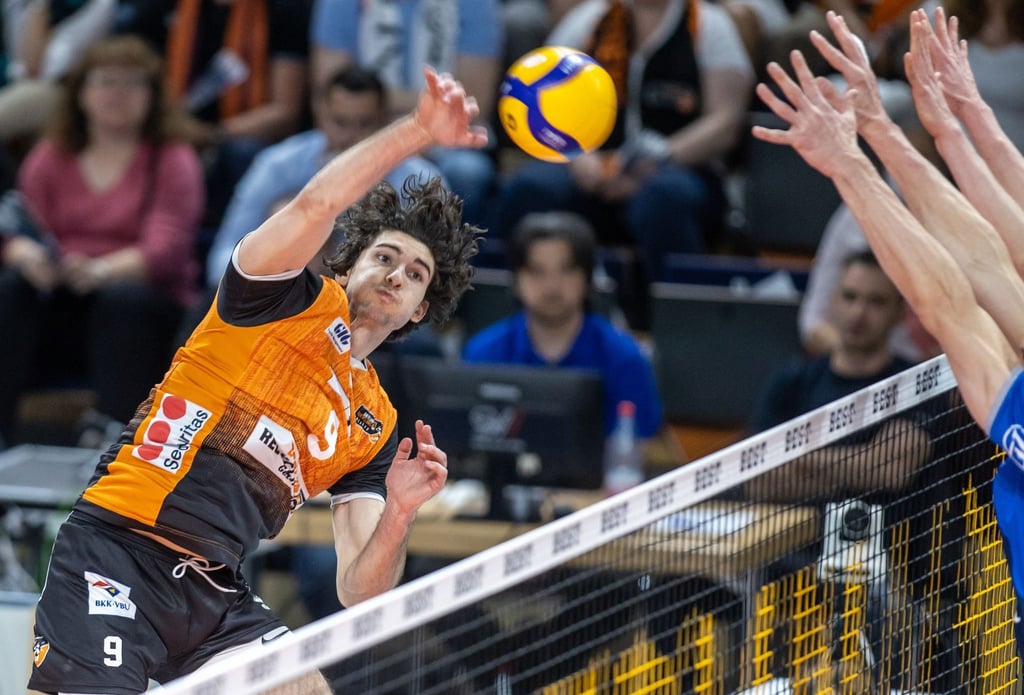 Berlins Timothee Carle spielt den Ball über das Netz.