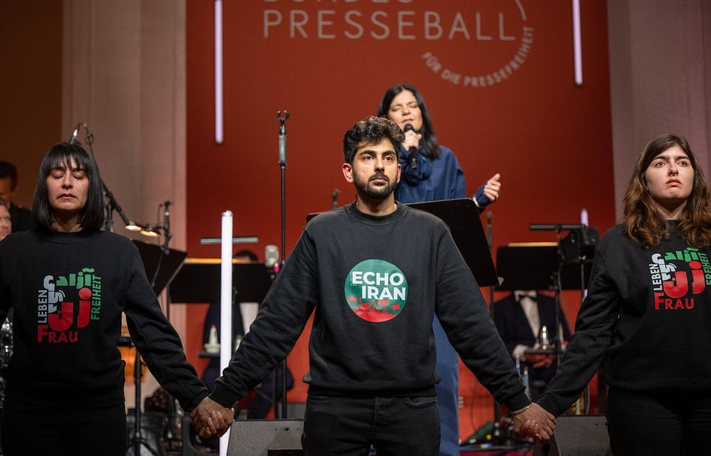 Mitglieder der Initiative Echo Iran halten sich an den Händen bei einer Aktion zu Verboten im Iran auf dem Bundespresseball.