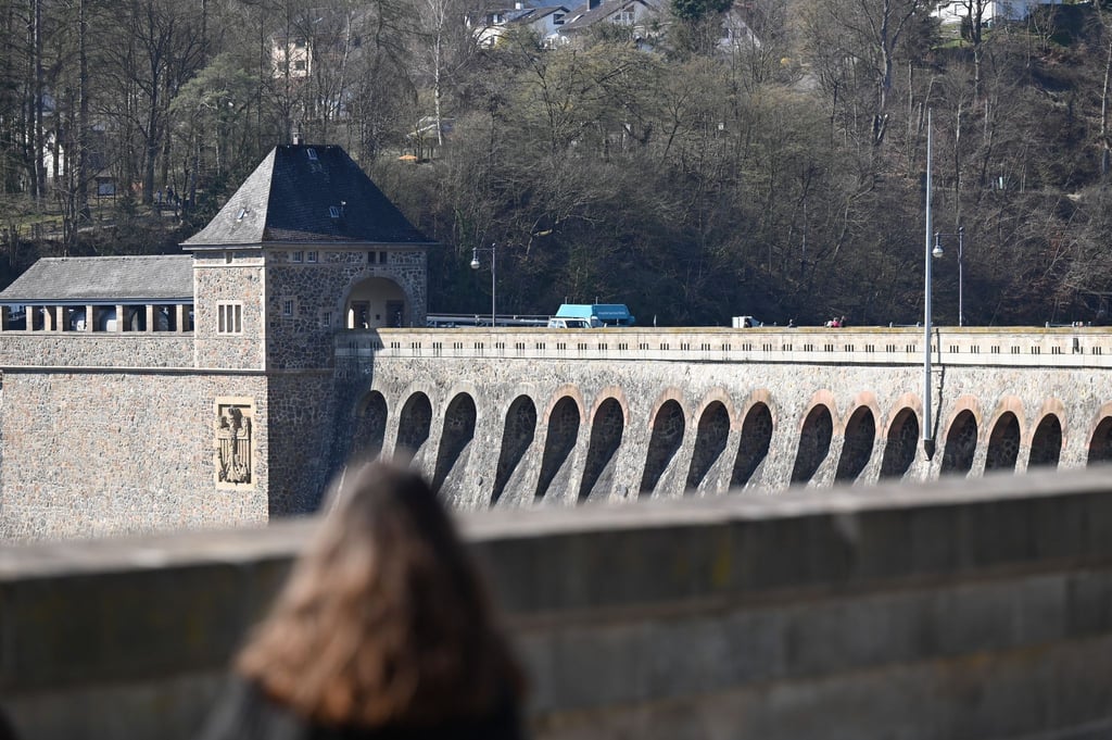 Eine Frau läuft über die Sperrmauer des Edersees. Das neue Besucherzentrum am Edersee informiert über Angebote und Aktivitäten in der Region.