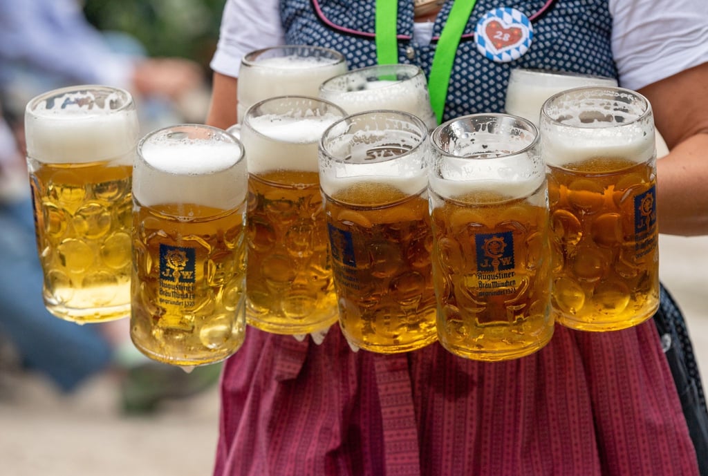 Eine Bedienung trägt acht Maß Bier.