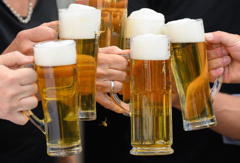 Eine Gesellschaft stößt mit Bier an.