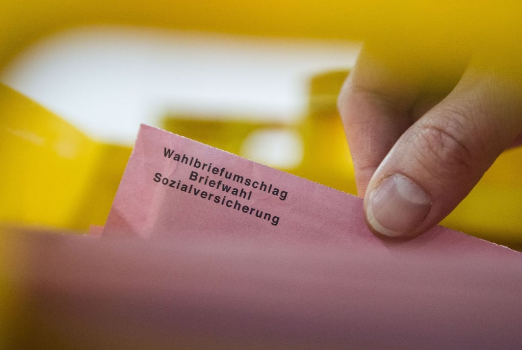 Ein Besucher eines Presserundgangs zieht in einer Lagerhalle in Berlin einen Wahlbrief aus einer Kiste.