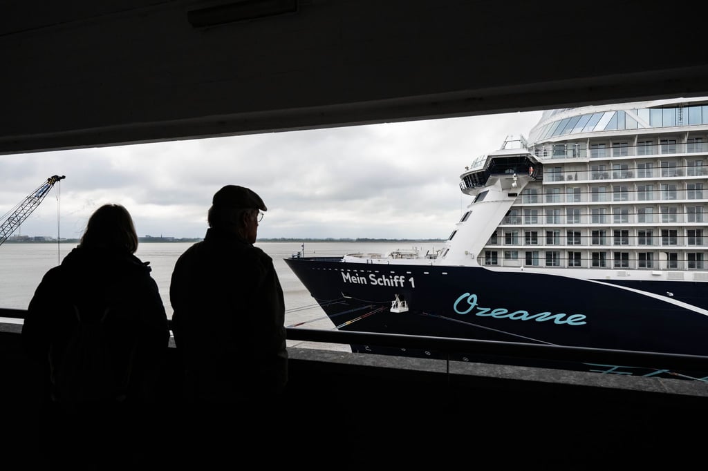 Passanten schauen auf das Kreuzfahrtschiff „Mein Schiff 1“ an der Columbuskaje.
