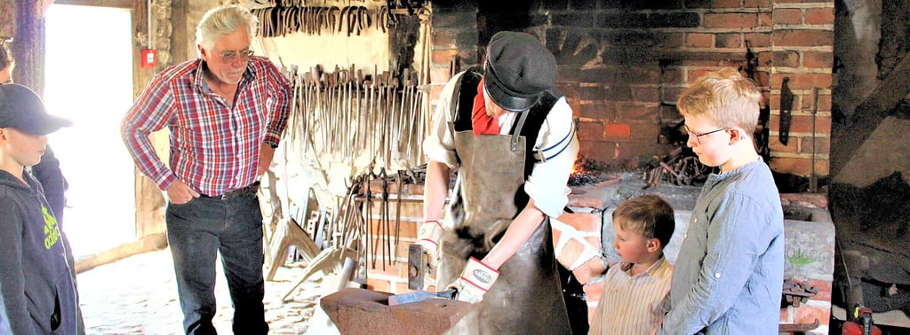 Museumsschmied Holger Schwerin (Mitte) arbeitete im Freilichtmuseum gestern an Esse und Amboss. Auf junge wie alte Besucher übt das traditionelle Schmiedehandwerk immer wieder eine große Faszination aus.