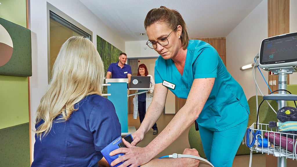 Stationsleiterin Claudia Bausdorf (links), Oberärztin Katharina Wildgrube und Gesundheits- und Krankenpfleger Patrick Schmidt testen die mobile Vorsorgestation des neuen Salus-Klinikkomplexes.