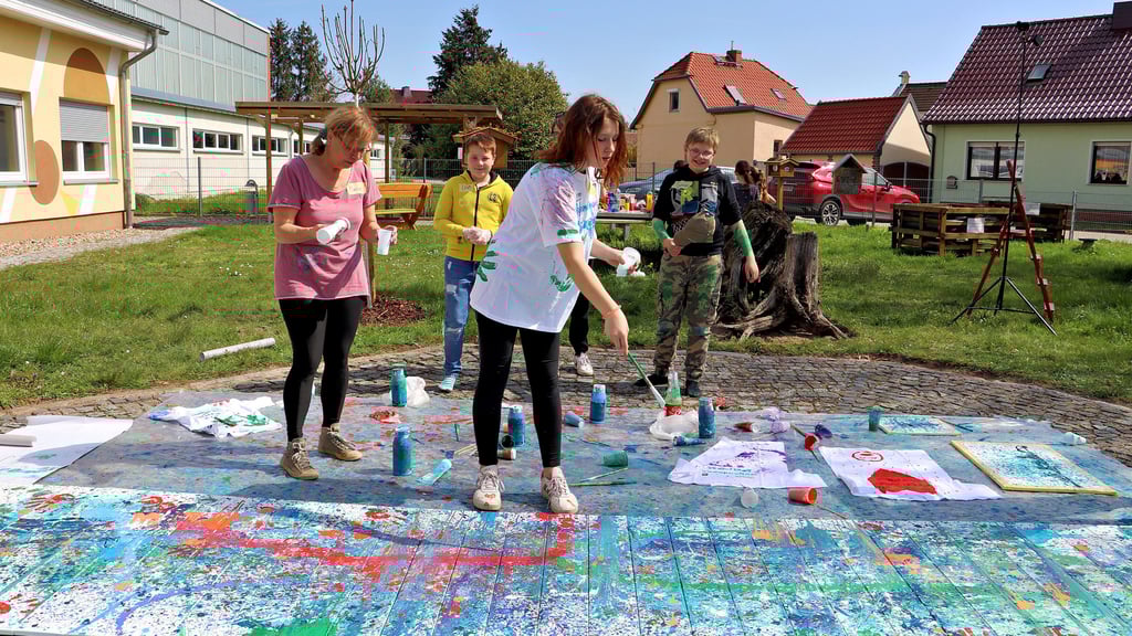 Das macht Spaß: Vivien trägt Farbe auf den meterlangen Farbuntergrund auf.