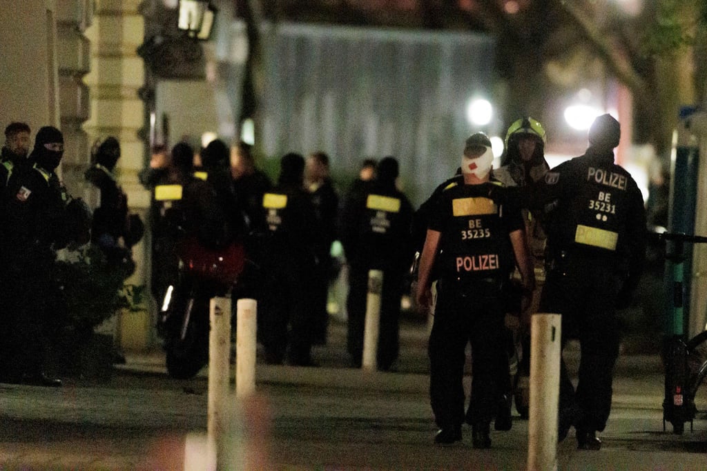 Ein Polizist trägt einen Kopfverband nachdem Polizisten ein Geschäft an der Keithstraße gestürmt hatten. Dort war es zu einem Überfall auf ein Geschäft gekommen, bei dem auch eine Geisel genommen wurde.