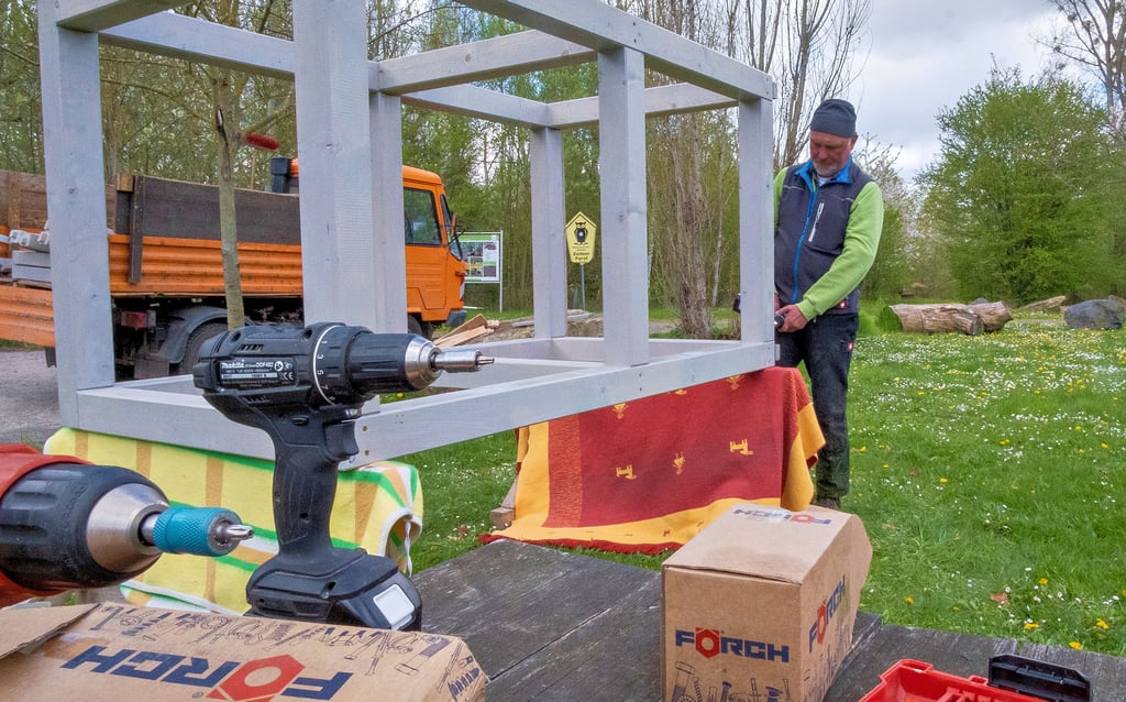 Gemeindearbeiter Bernd Bohndorf bereitet einen der sechs Holzaufsteller vor, bevor er auf der Wiese platziert wird.
