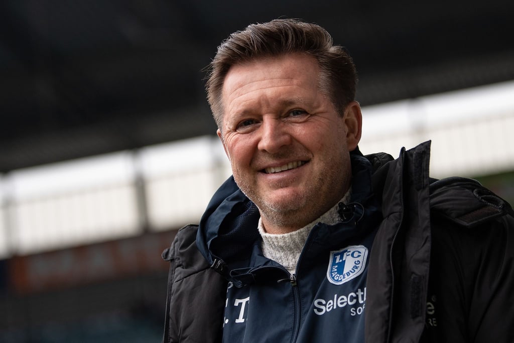 Magdeburgs Trainer Christian Titz lächelt vor dem Spiel im Stadion.