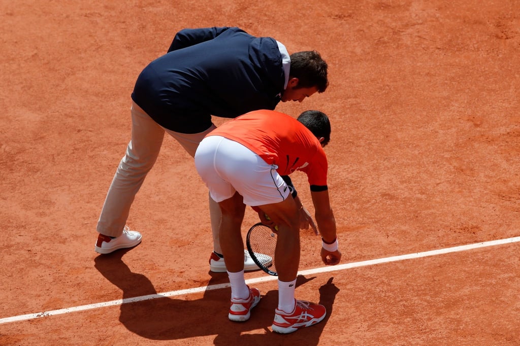 Novak Djokovic (r) diskutiert mit einem Offiziellen um einen Punktgewinn.