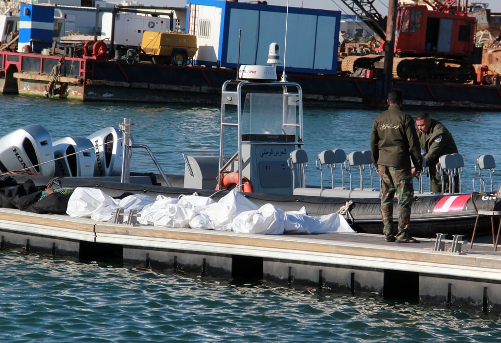 Einsatzkräfte der tunesischen Küstenwache im Hafen von Sfax neben zugedeckten Leichen auf einem Steg (Archivbild).